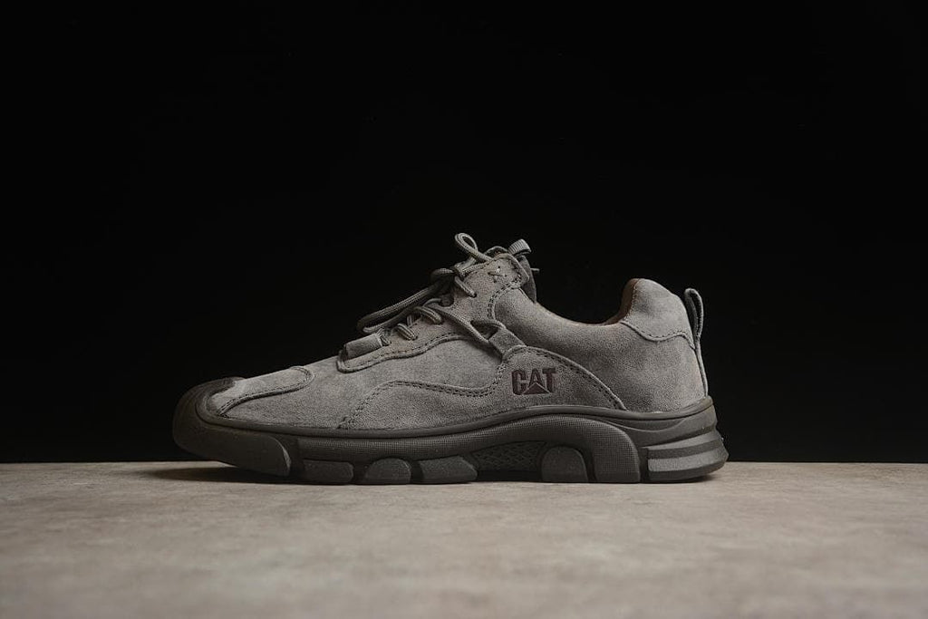 Side view of a gray CAT Tramp Hike Low sneaker with a dark outsole.