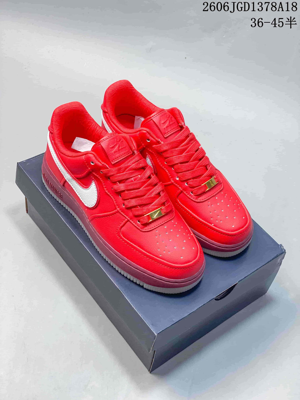 Pair of red Nike Air Force 1 low-top sneakers with white Swooshes and mauve-pink midsoles