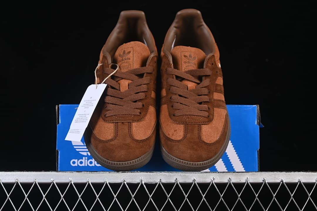 Front view of the brown sneakers displayed on a blue shoe box
