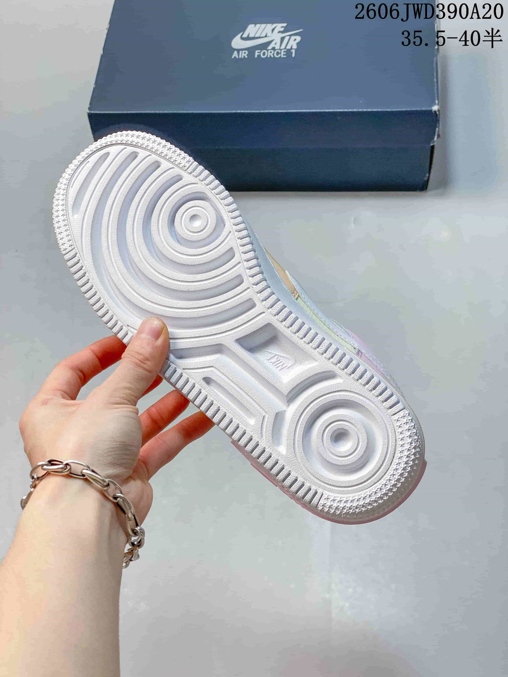 Underside of a Nike Air Force 1 sneaker showing the patterned white rubber outsole.