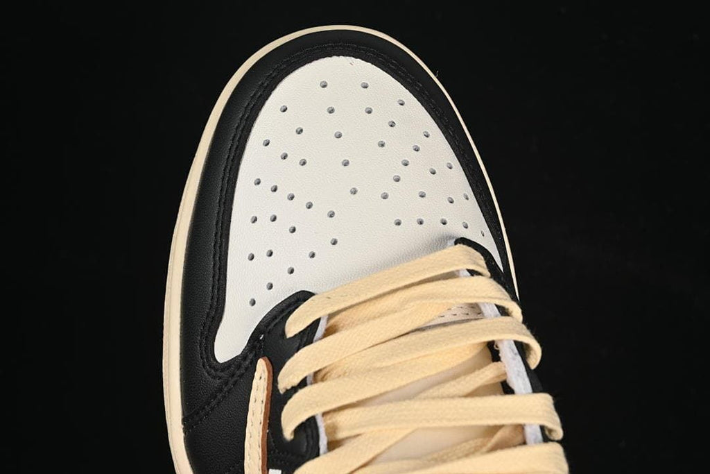 Top view of perforated white toe box, black trim, and cream laces