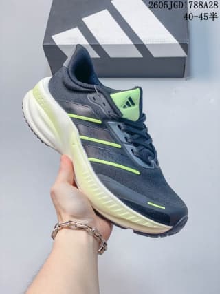 Dark gray Reebok-style training shoe with lime accents and a light-colored sculpted sole; box label shows 40–45.