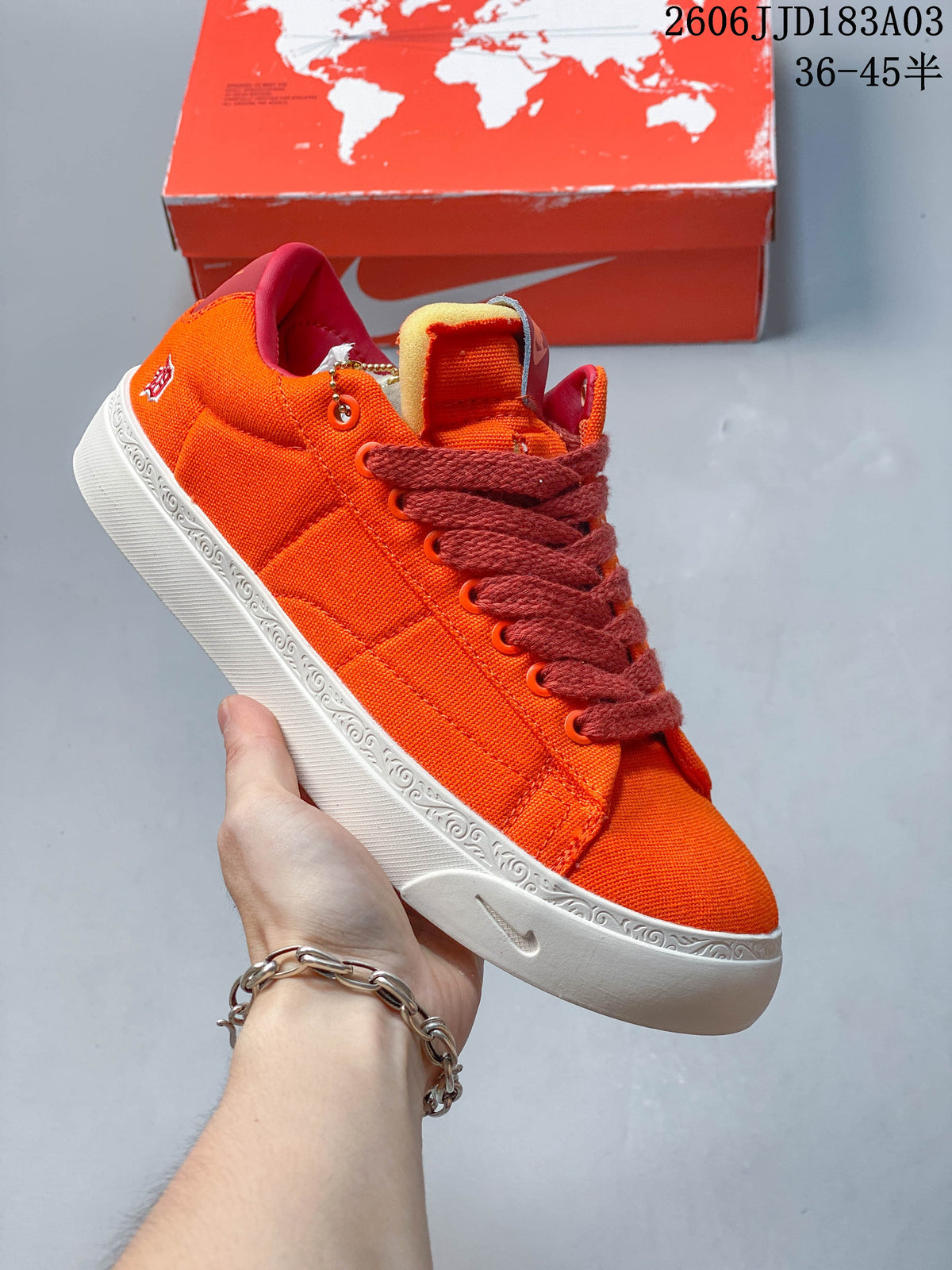 Orange low-top lace-up sneaker with a white decorated midsole
