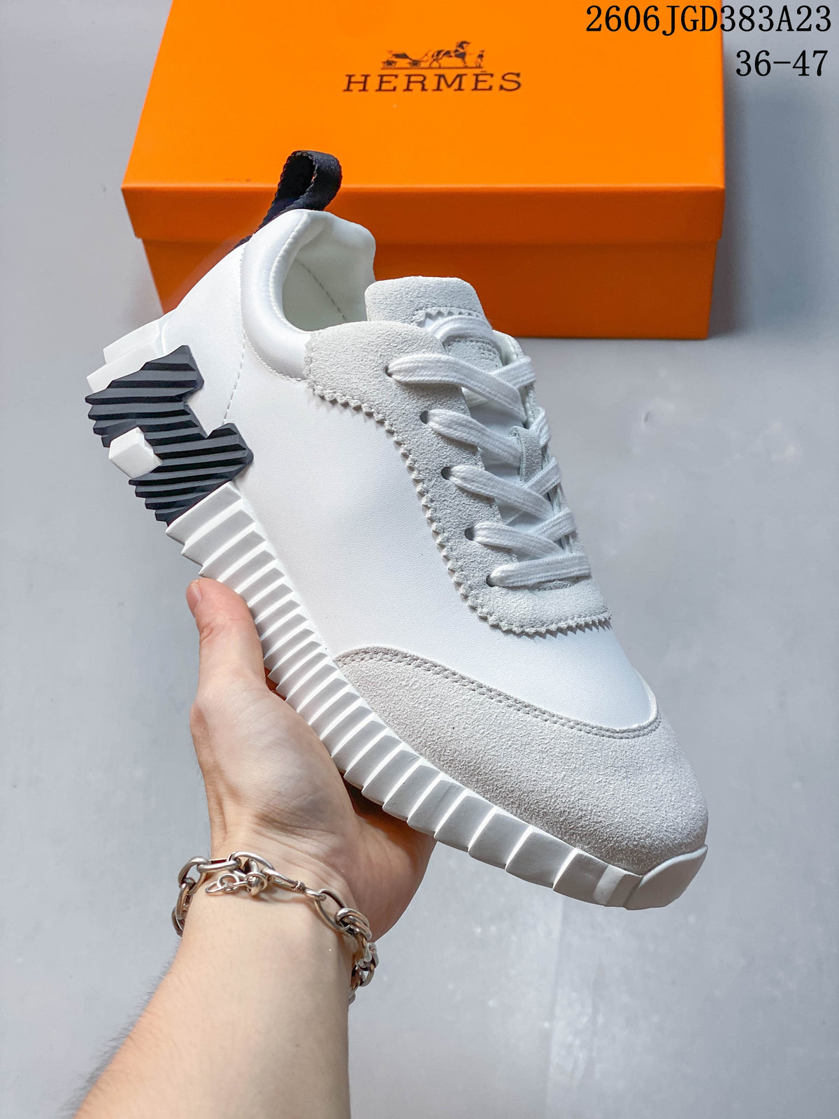 Side view of a white low-top sneaker showing its ribbed sole and contrasting heel detail.