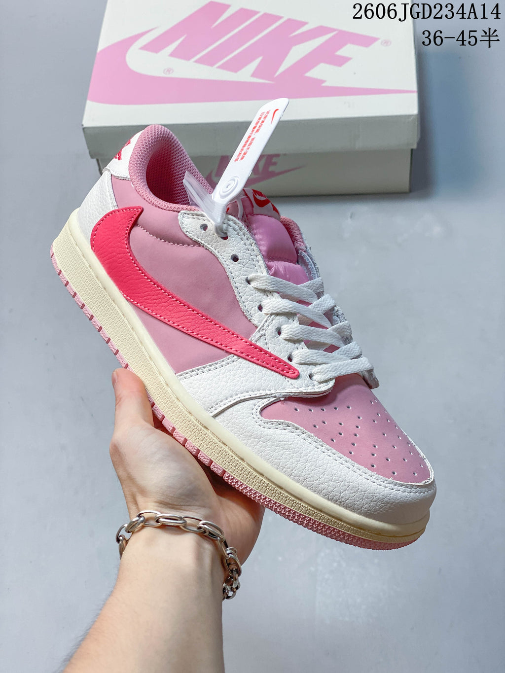 Angled side view of the pink and white sneaker with a contrasting Swoosh
