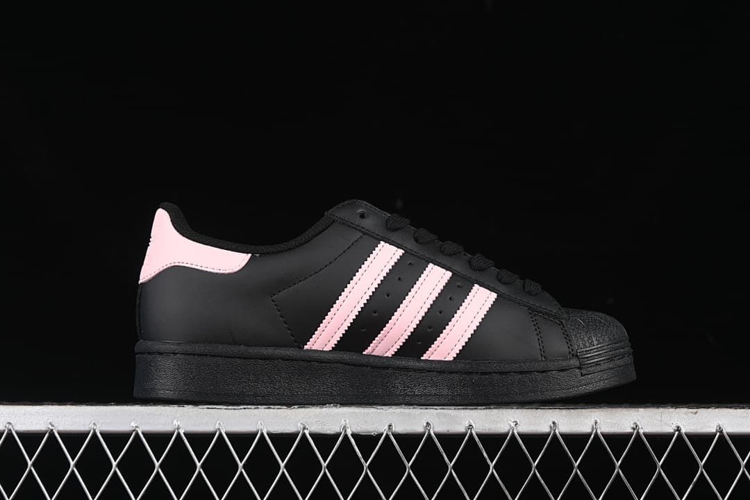 Side profile showing black uppers, pink stripes and pink heel accents