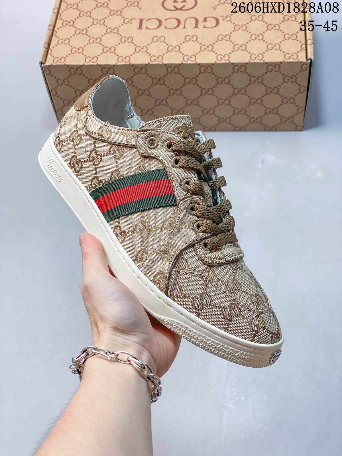 Angled view of a beige GG-patterned low-top sneaker with a green-and-red stripe; the image overlay states 35–45