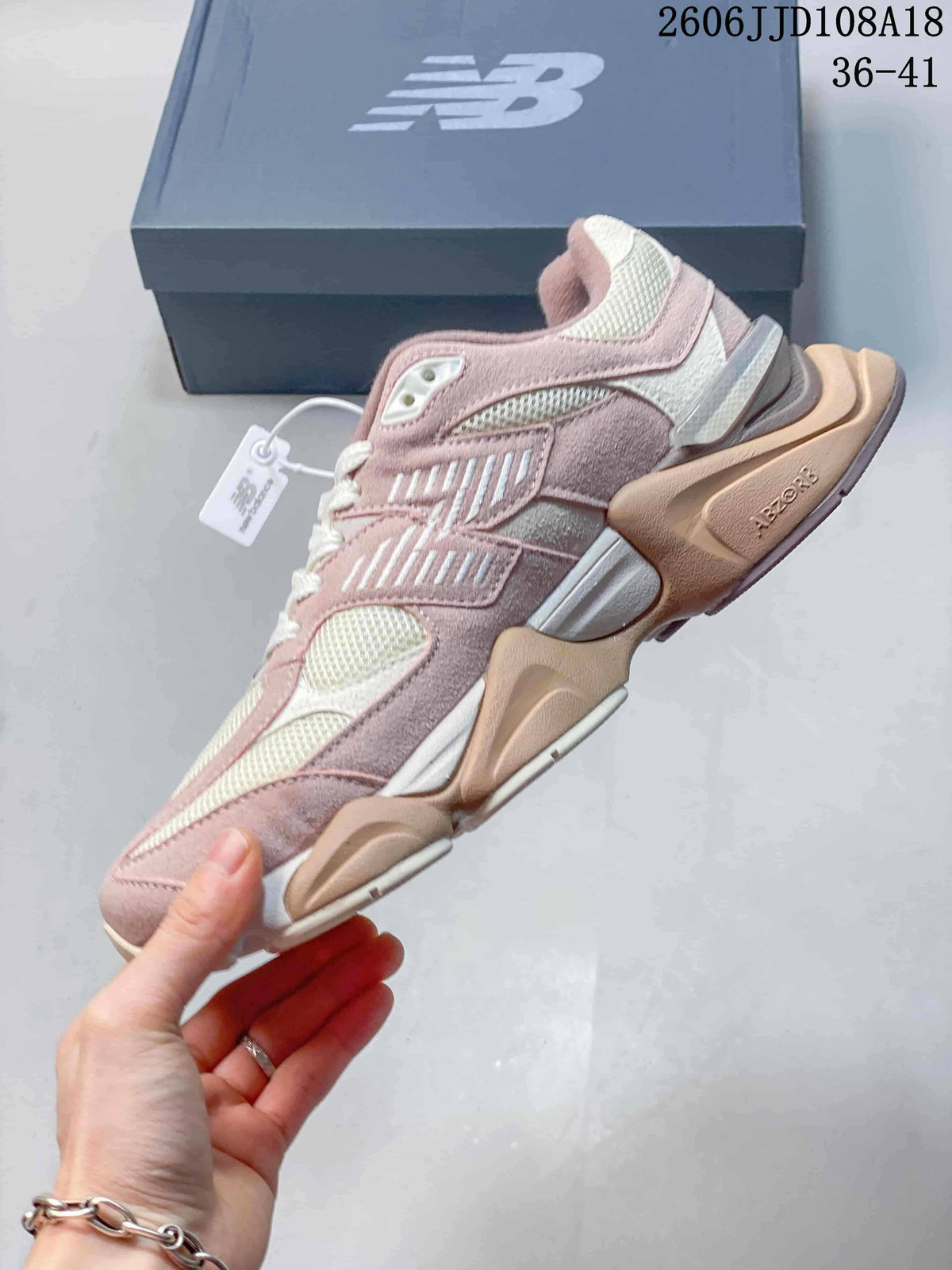 Side view showing the layered panels and chunky sole of a pink New Balance 9060