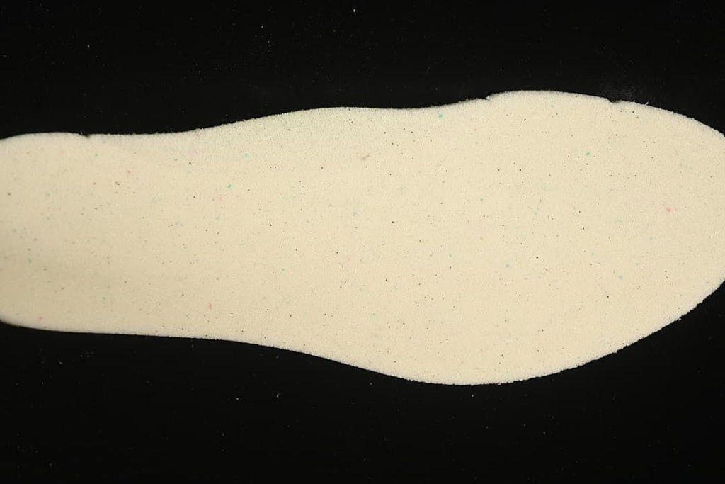 Light-colored shoe insole shown on a dark background