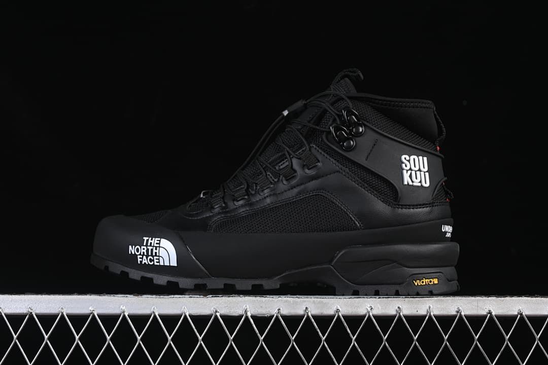 Black mid-height hiking shoe in profile with white logo details
