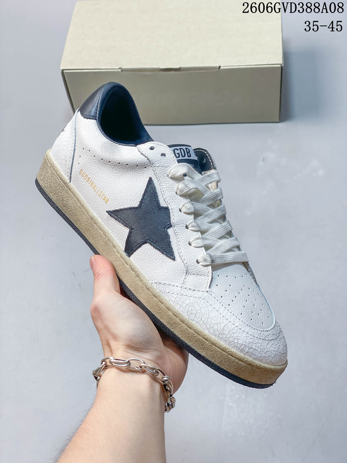 Side view of the sneaker with a navy star, white upper and contrasting sole