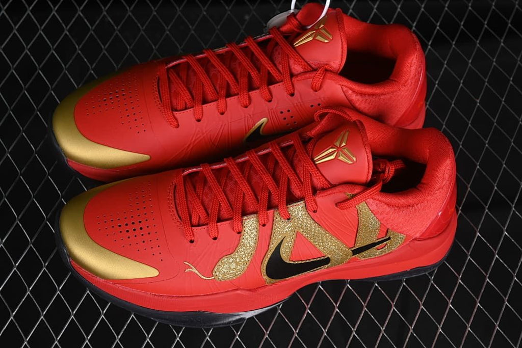 Pair of red and gold low-top basketball shoes viewed from above