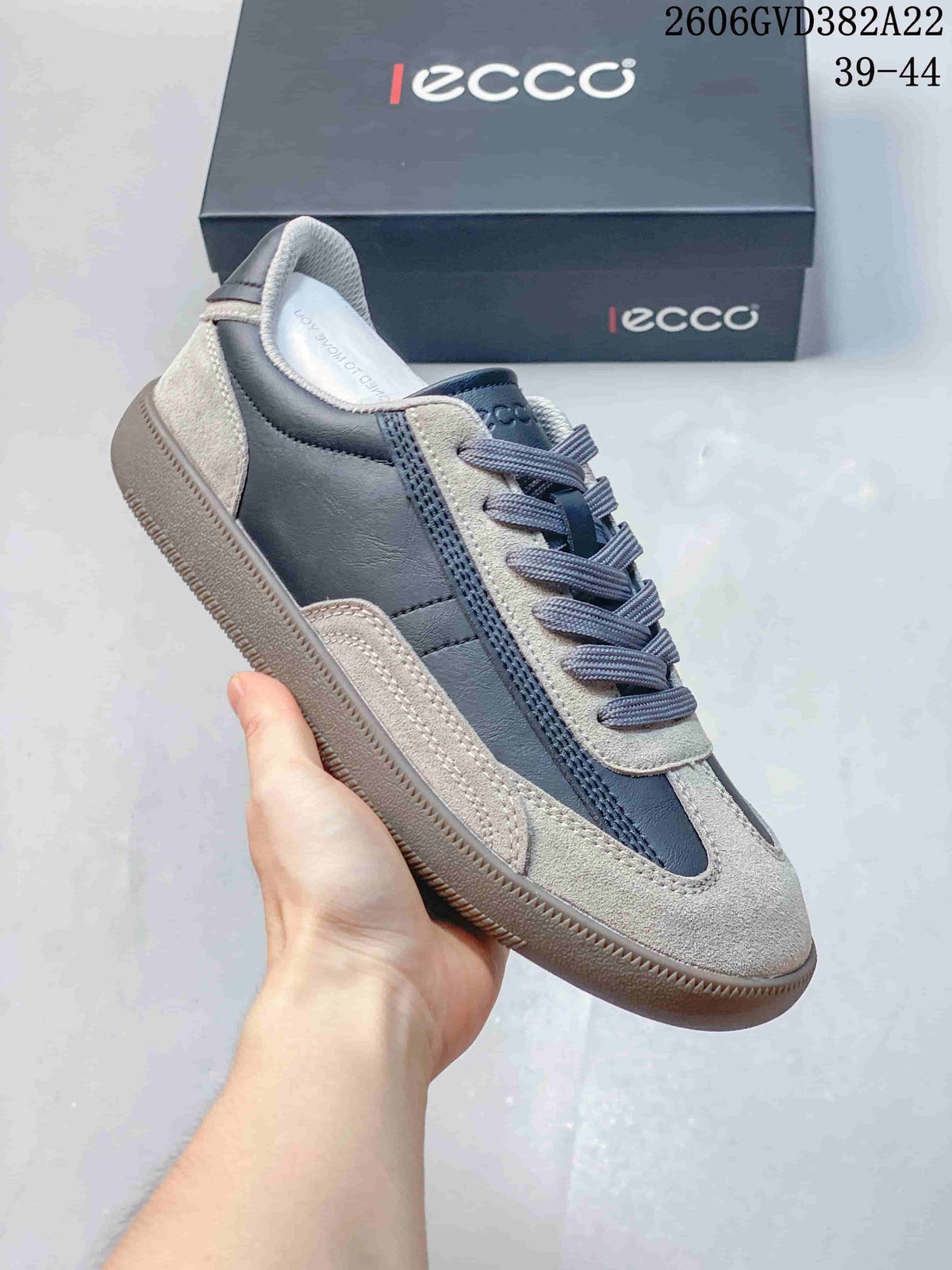 Side view of a gray and dark blue ECCO low-top lace-up sneaker.