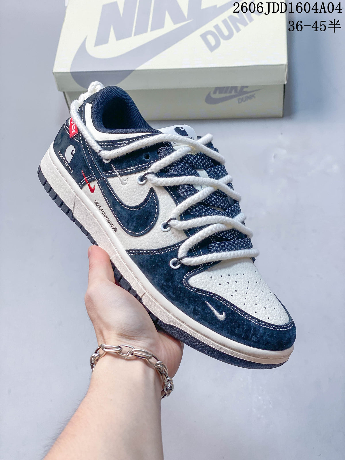 Navy and cream low-top sneaker with thick white laces, shown beside a Nike Dunk box.