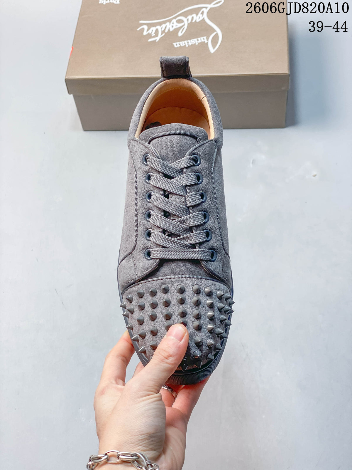Front view of a grey lace-up sneaker with studded toe detailing
