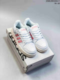 White adidas Entrap sneakers with pink stripes displayed on a shoe box