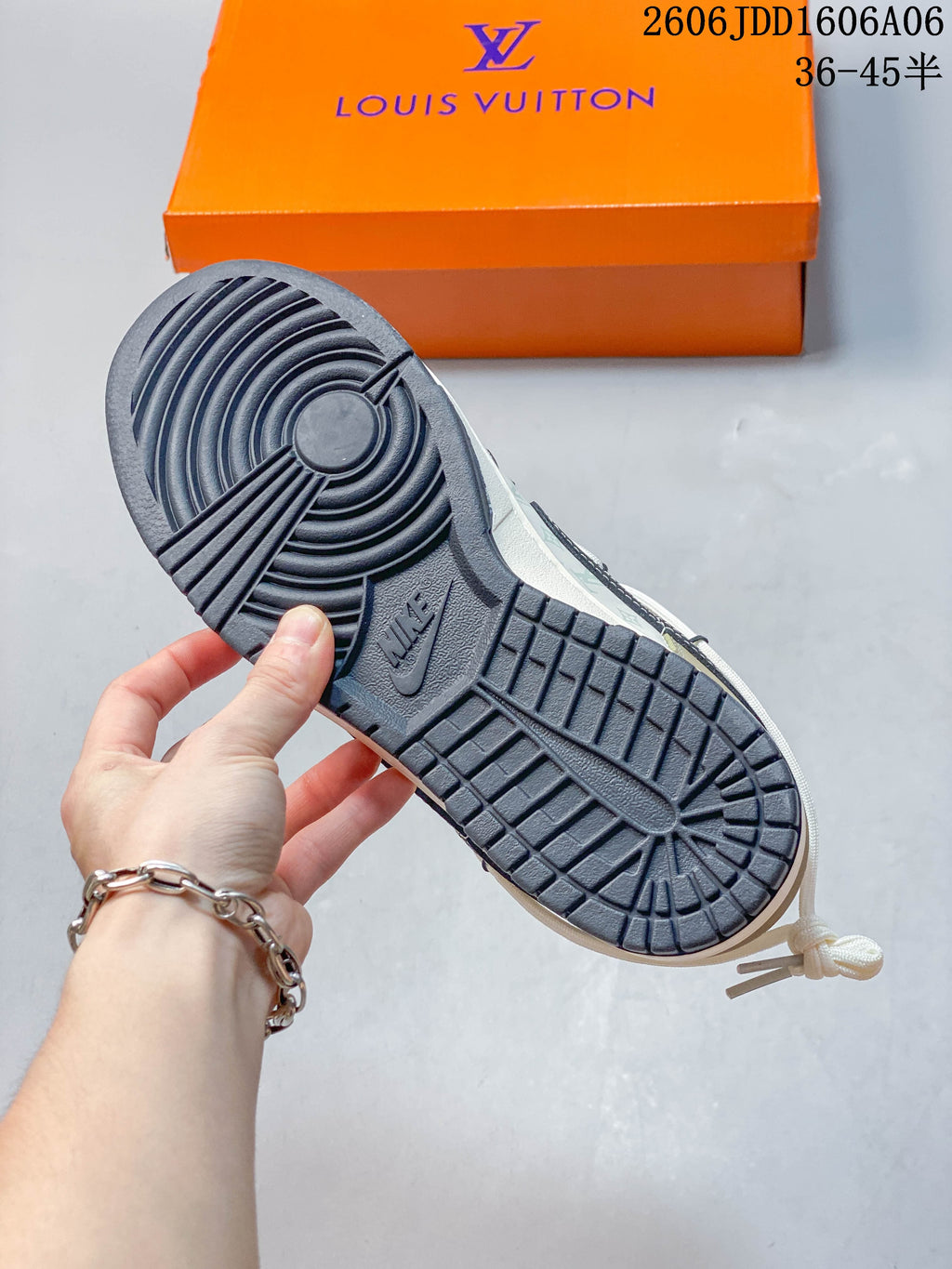 Close-up of the dark outsole and orange box beneath a Nike SB Dunk Low sneaker