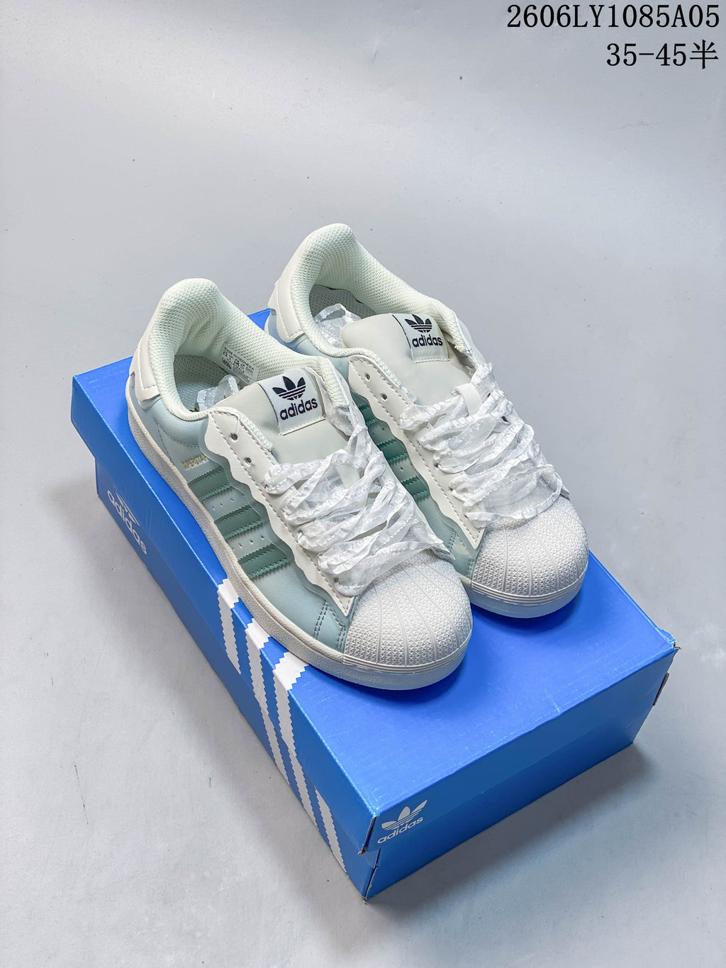 Pair of pale mint Superstar sneakers with white ruffle-style laces