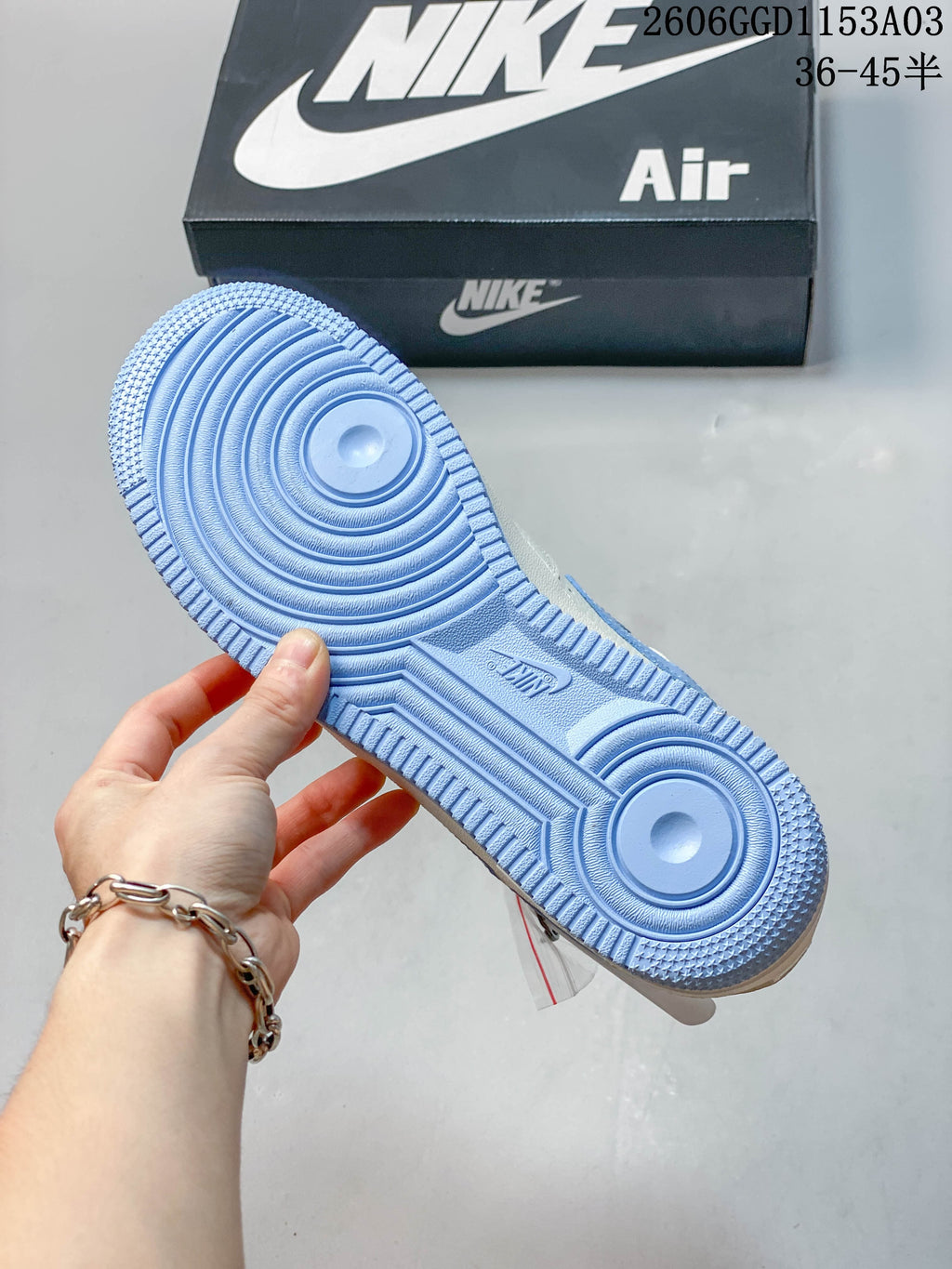 Light blue outsole with circular tread pattern shown against a Nike Air shoebox