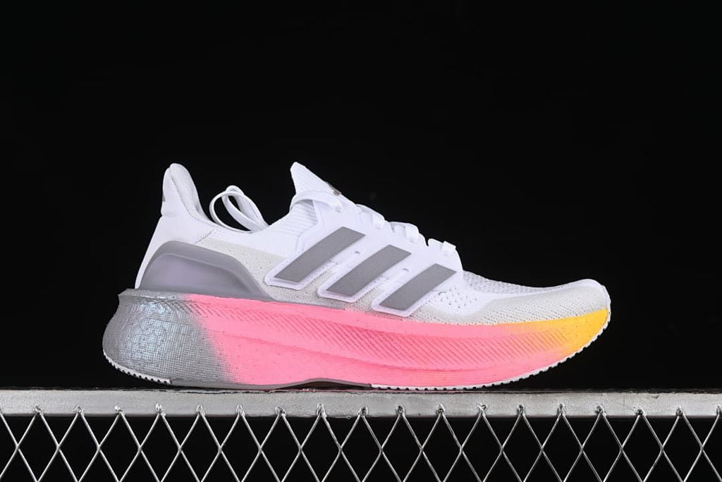 Side profile showing the white upper and pink-to-yellow midsole