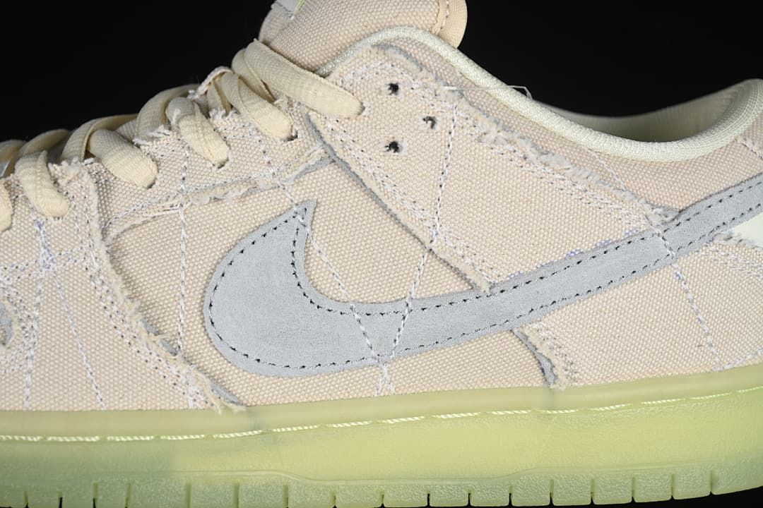 Close-up of the gray Swoosh, pale upper, and frayed panel edges