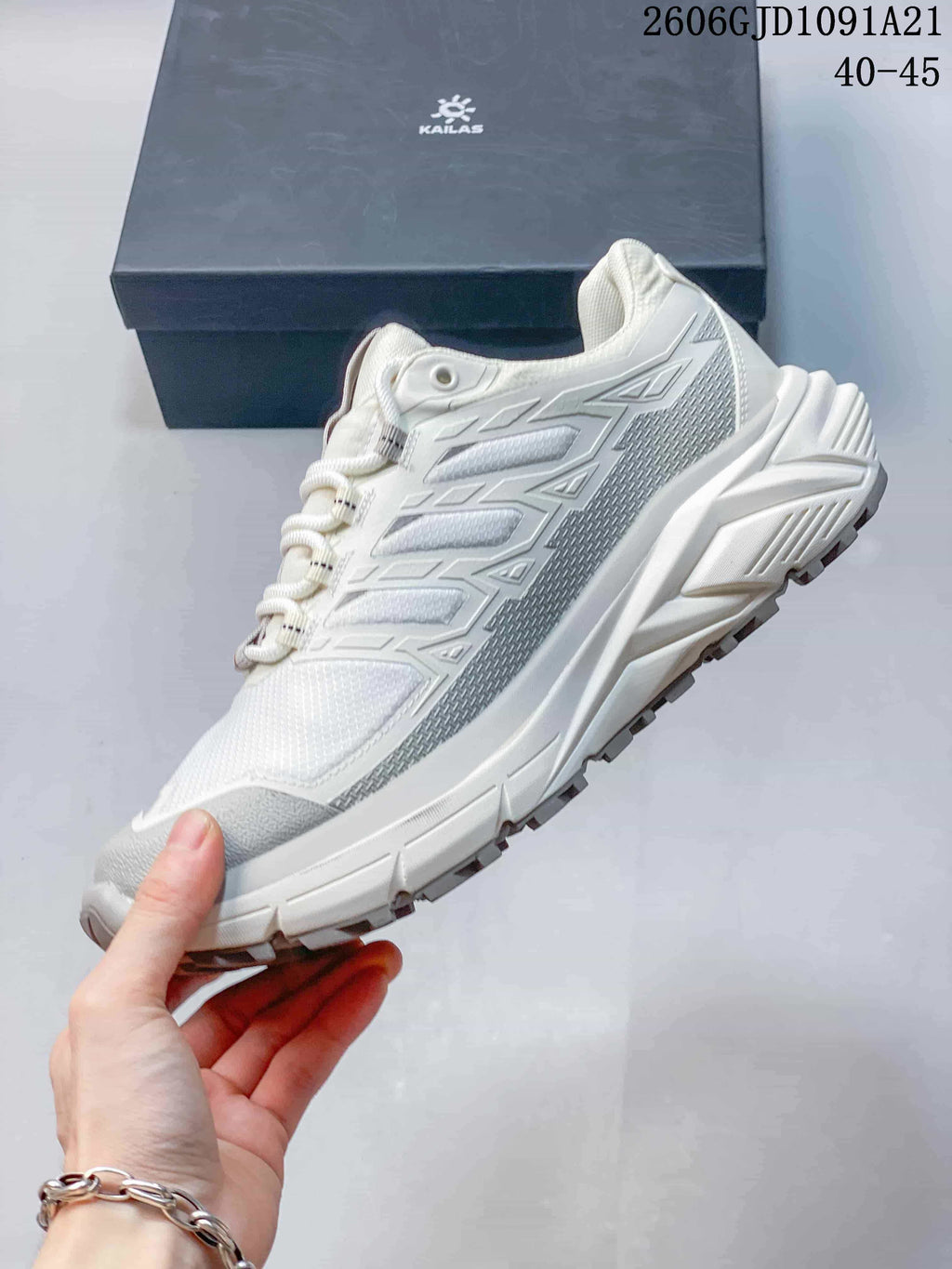 Side profile of a white and gray Kailas trail running shoe