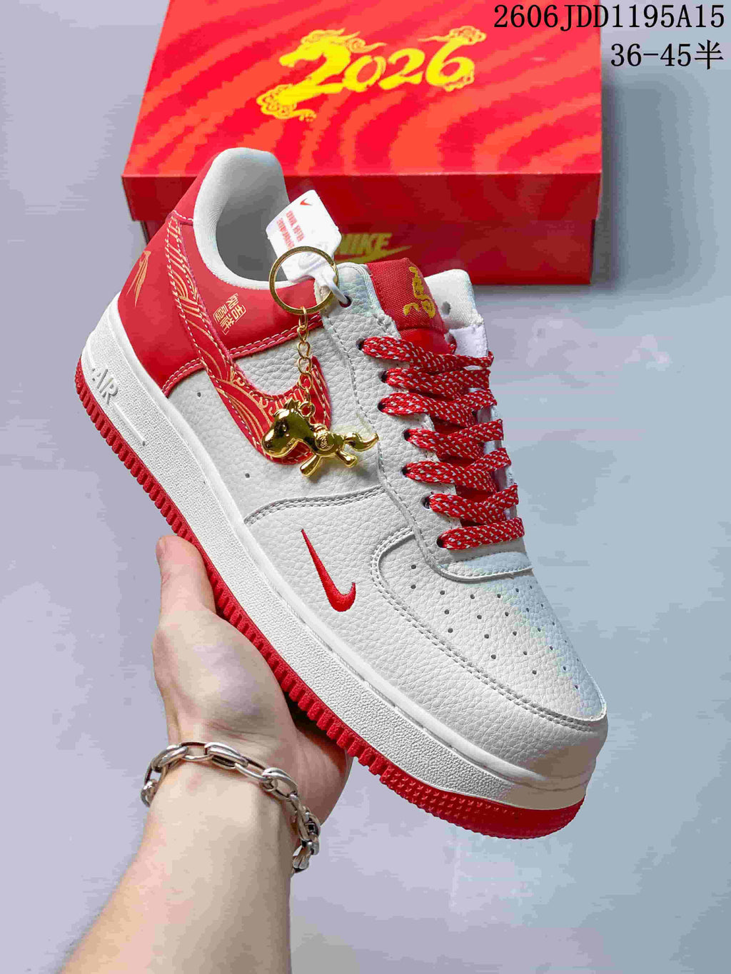Angled side view showing white and red panels, patterned Swoosh accent, and horse-themed charm