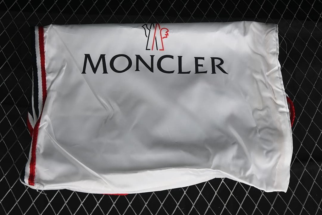 White Moncler-branded shoe bag with red trim.