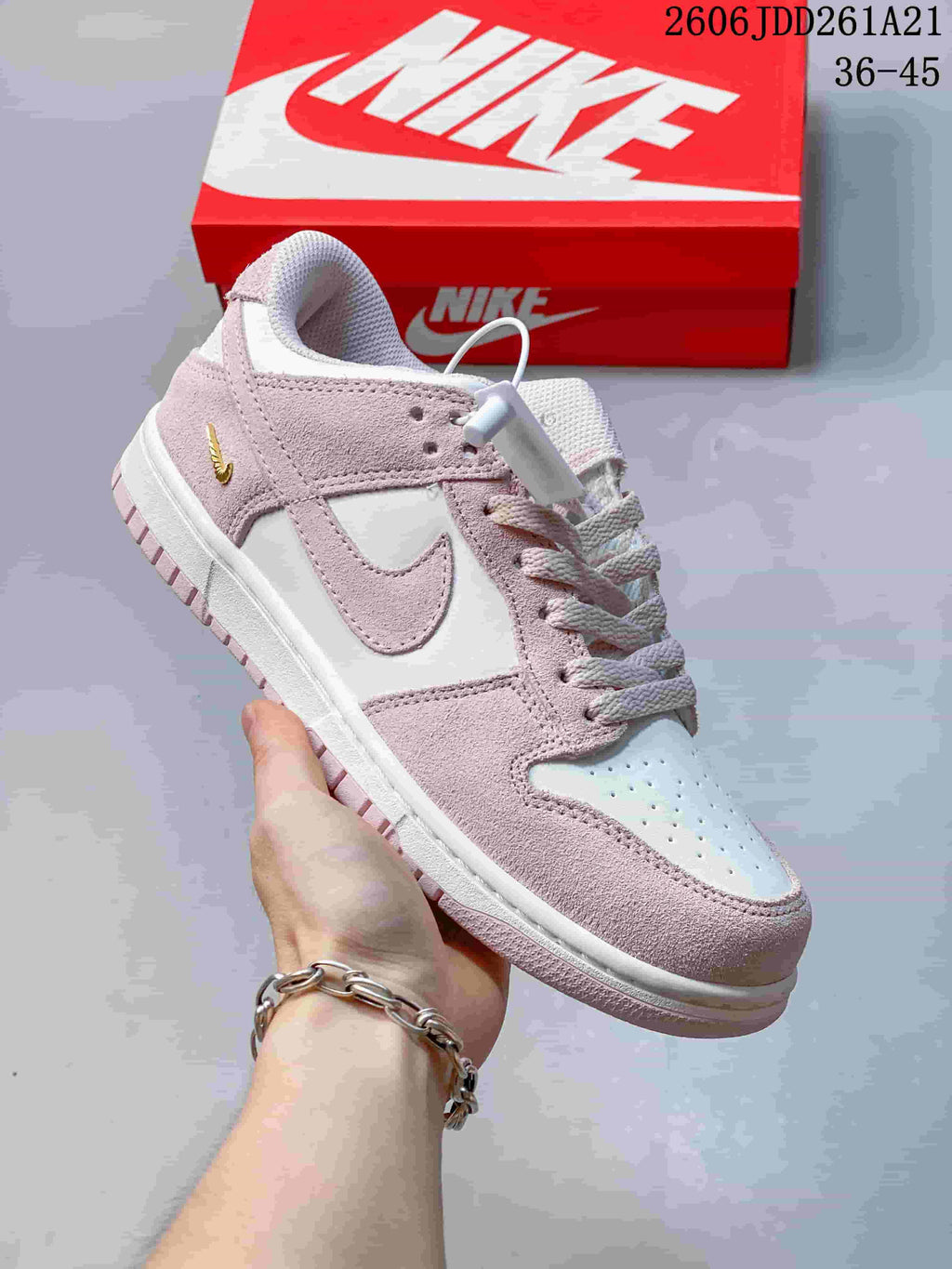 Pink and white low-top Nike Dunk sneaker with pale pink panels