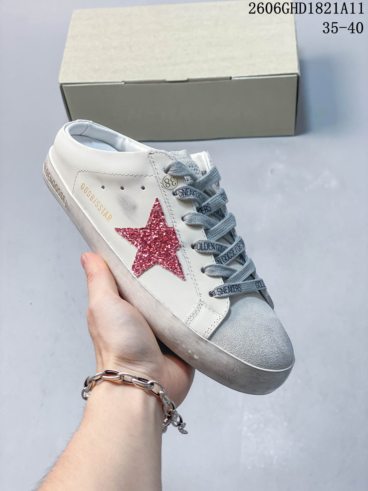 Angled side view of the sneaker with a red glitter star, printed gray laces, and visible Golden Goose branding.