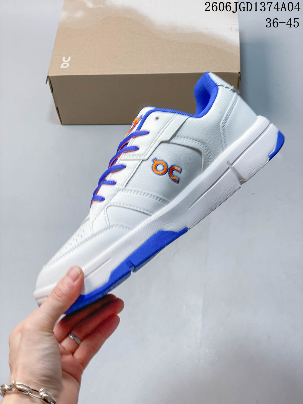 Side view of the white low-top sneaker with blue and orange details