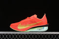 Side view of a coral-orange Nike ZoomX Vaporfly road-running shoe with yellow-green Swoosh and pale mint midsole.