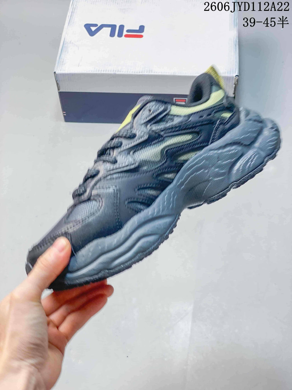 Side view of a charcoal-gray FILA sneaker with lime accents