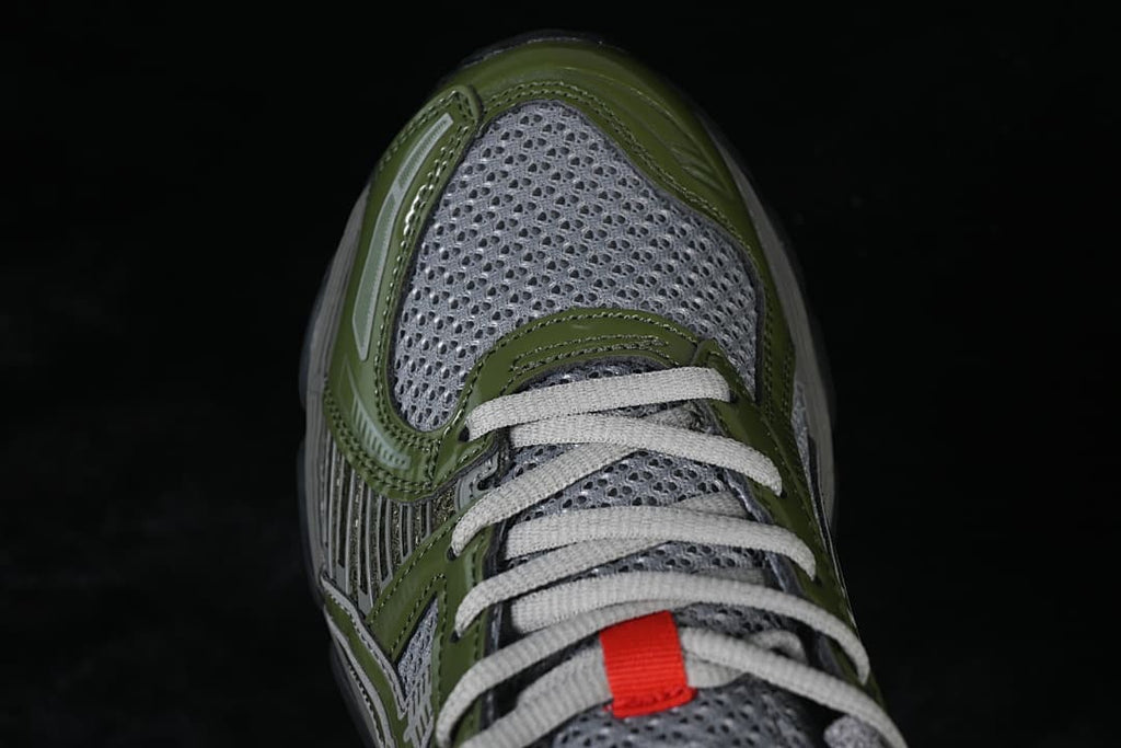 Top-down view of the gray toe, olive-green overlays, and laces.