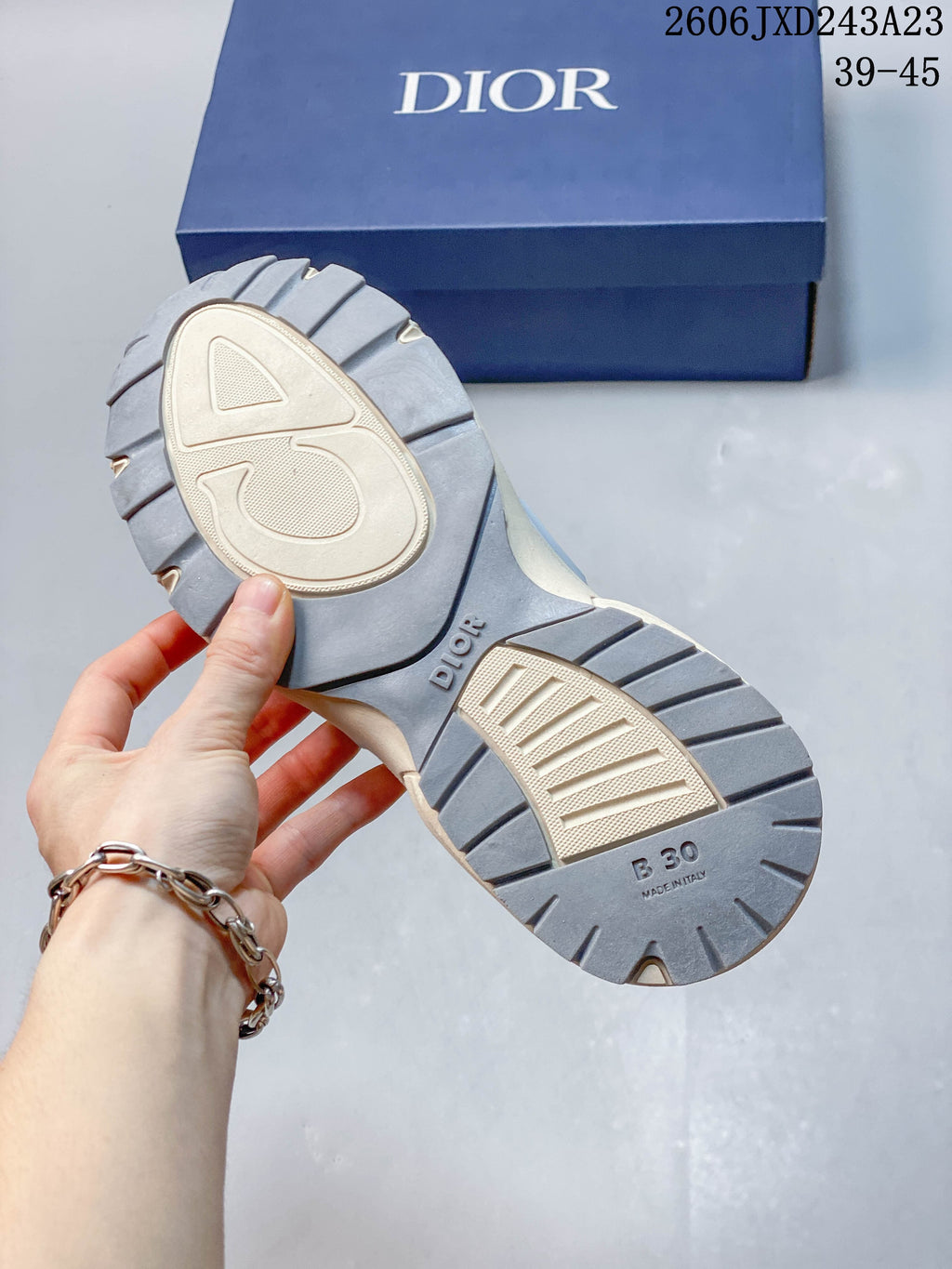 Underside of a Dior B30 sneaker showing the gray and light-colored tread and sole markings