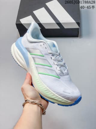 White training shoe with pale blue details, green side accents, and a blue outsole edge; box label shows 40–45.
