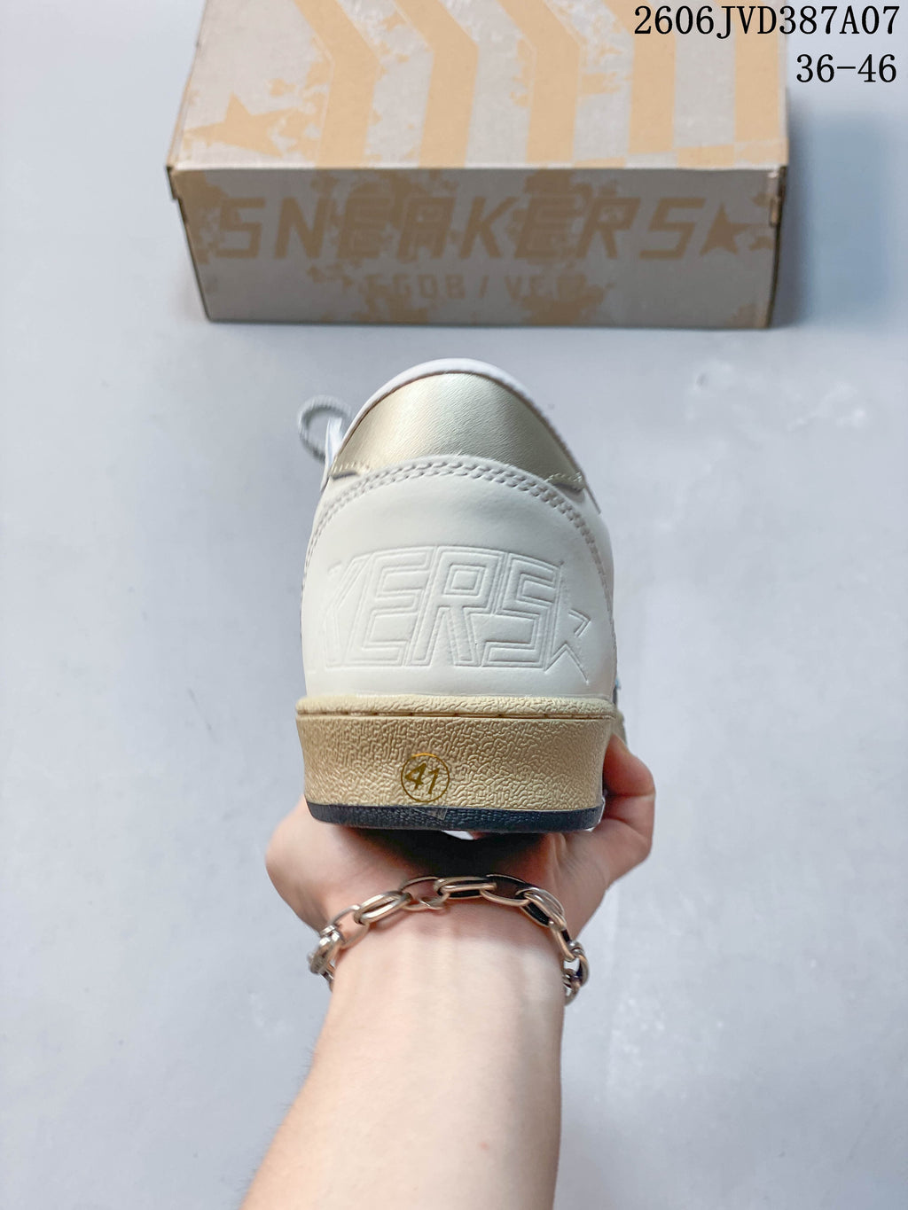 Rear view of the sneaker with embossed heel lettering and a distressed-look beige midsole