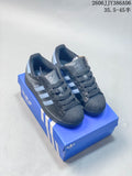 Pair of charcoal adidas Superstar 2 sneakers with pale blue stripes on a blue shoe box