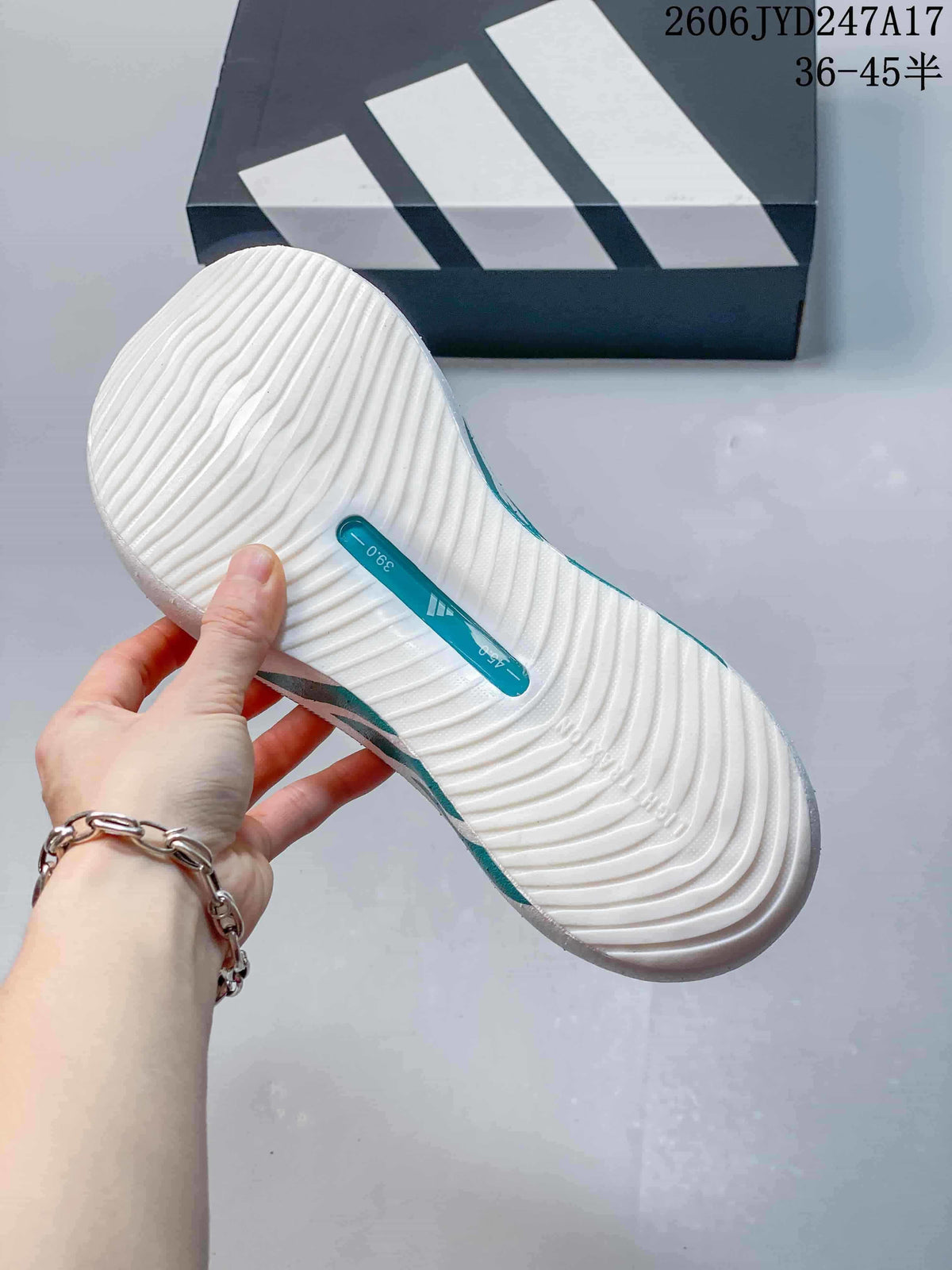Close-up of the grooved outsole on a white and teal sneaker