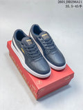 Pair of navy and white PUMA Caven 2.0 Retro low-top sneakers on a red shoe box