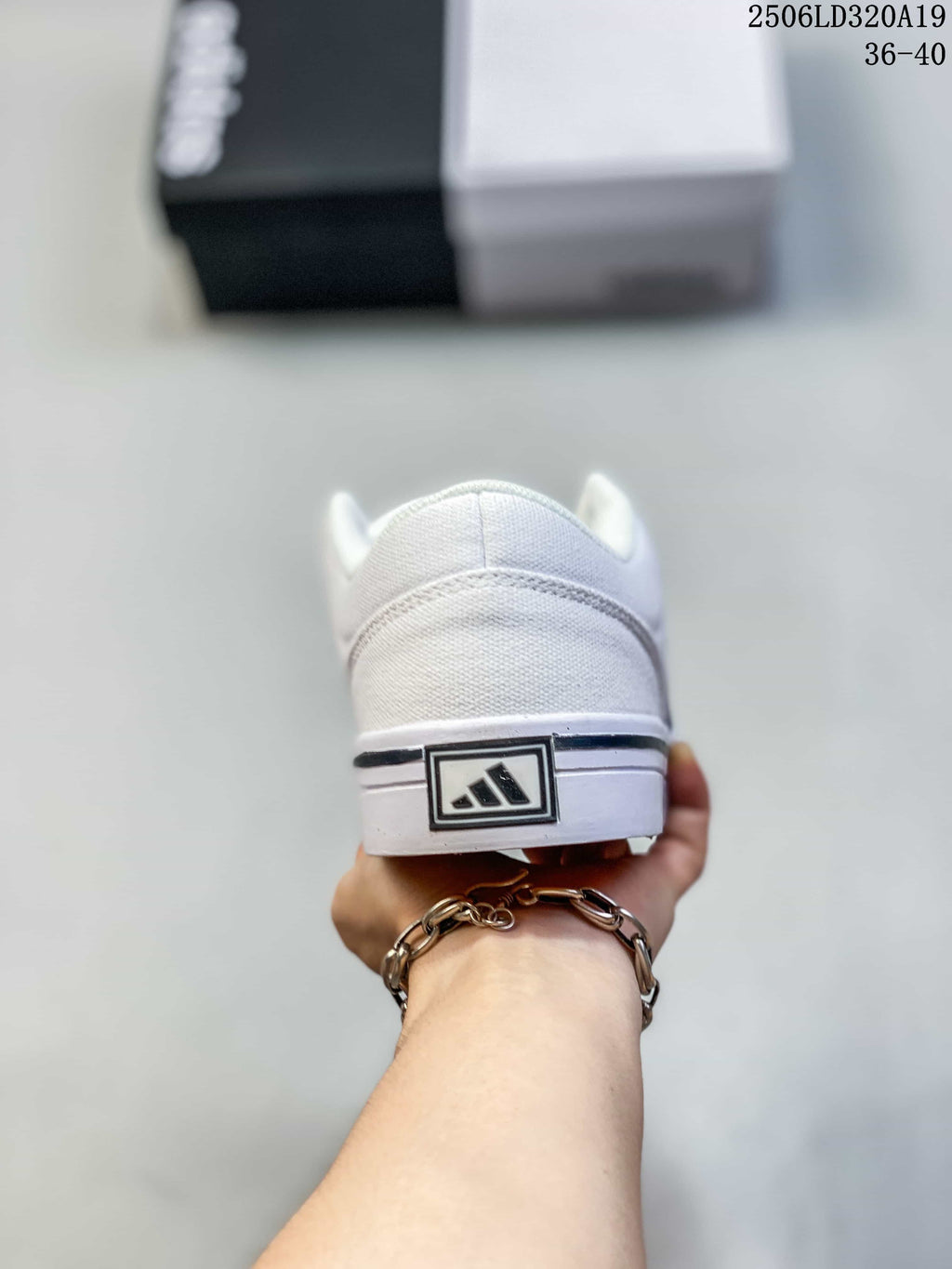 Rear view of the white sneaker showing the heel detail and flat sole.