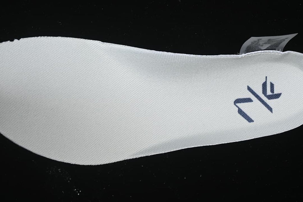 Close-up of a white shoe insole with a dark logo
