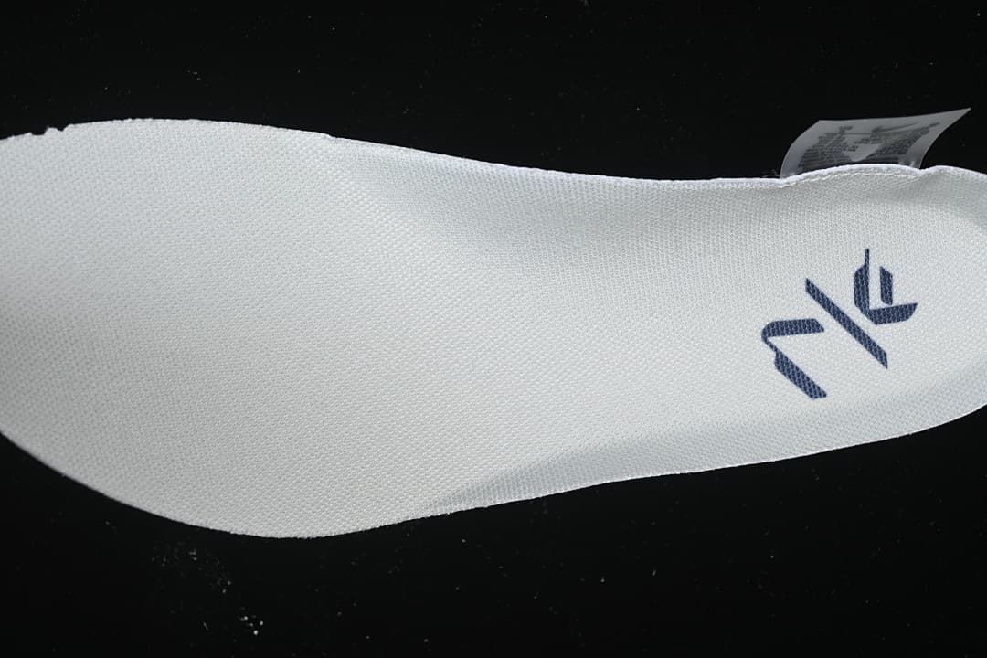 Close-up of a white shoe insole with a dark logo