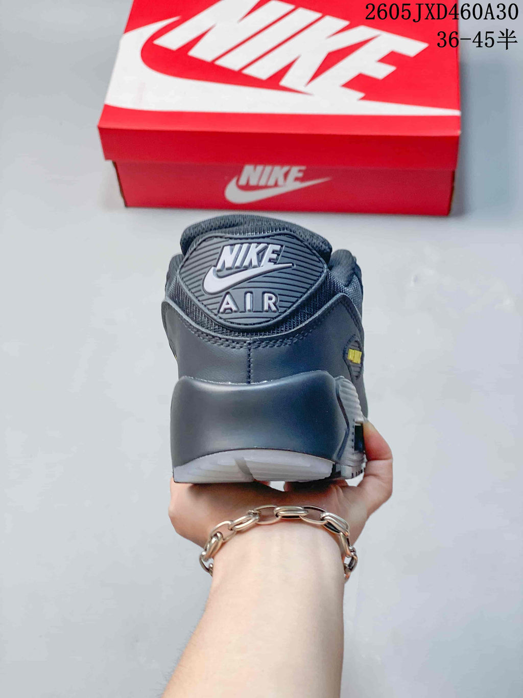 Rear view of a charcoal gray Nike Air Max 90 sneaker