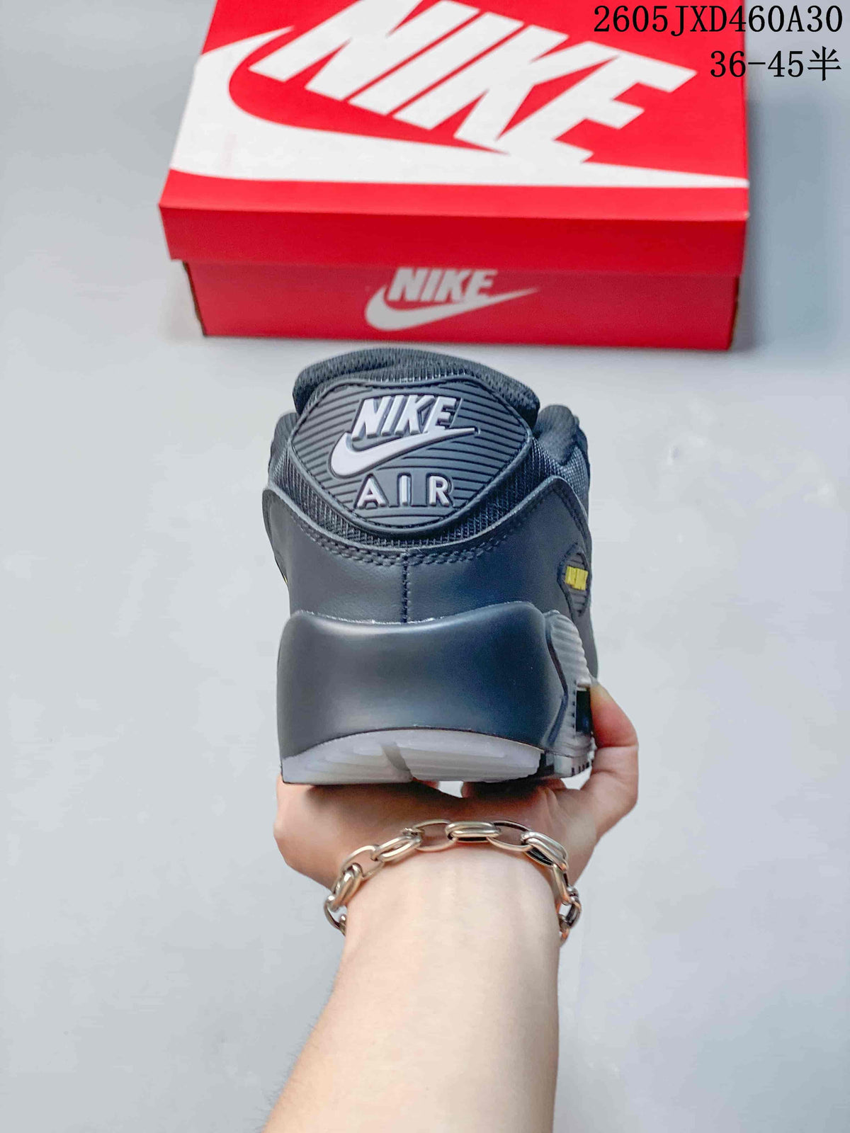 Rear view of a charcoal gray Nike Air Max 90 sneaker