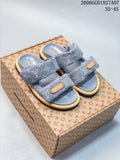 Pair of gray patterned two-strap slide sandals shown on a patterned box.