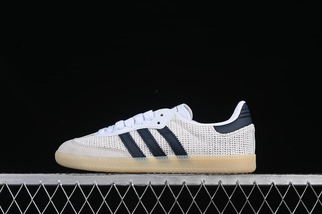 Side view of a white adidas Samba OG sneaker with navy stripes and a gum-look sole