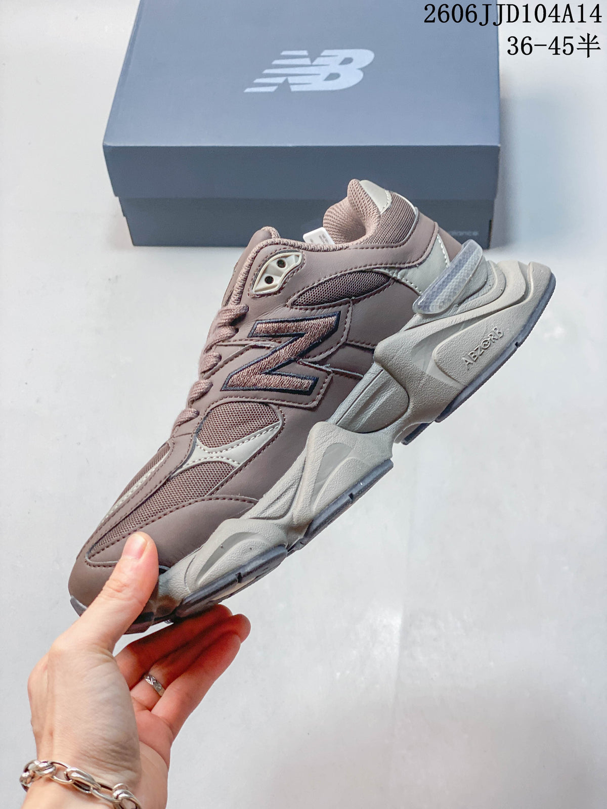 Side profile of a mauve and grey New Balance 9060 sneaker with layered panels and a large N logo.