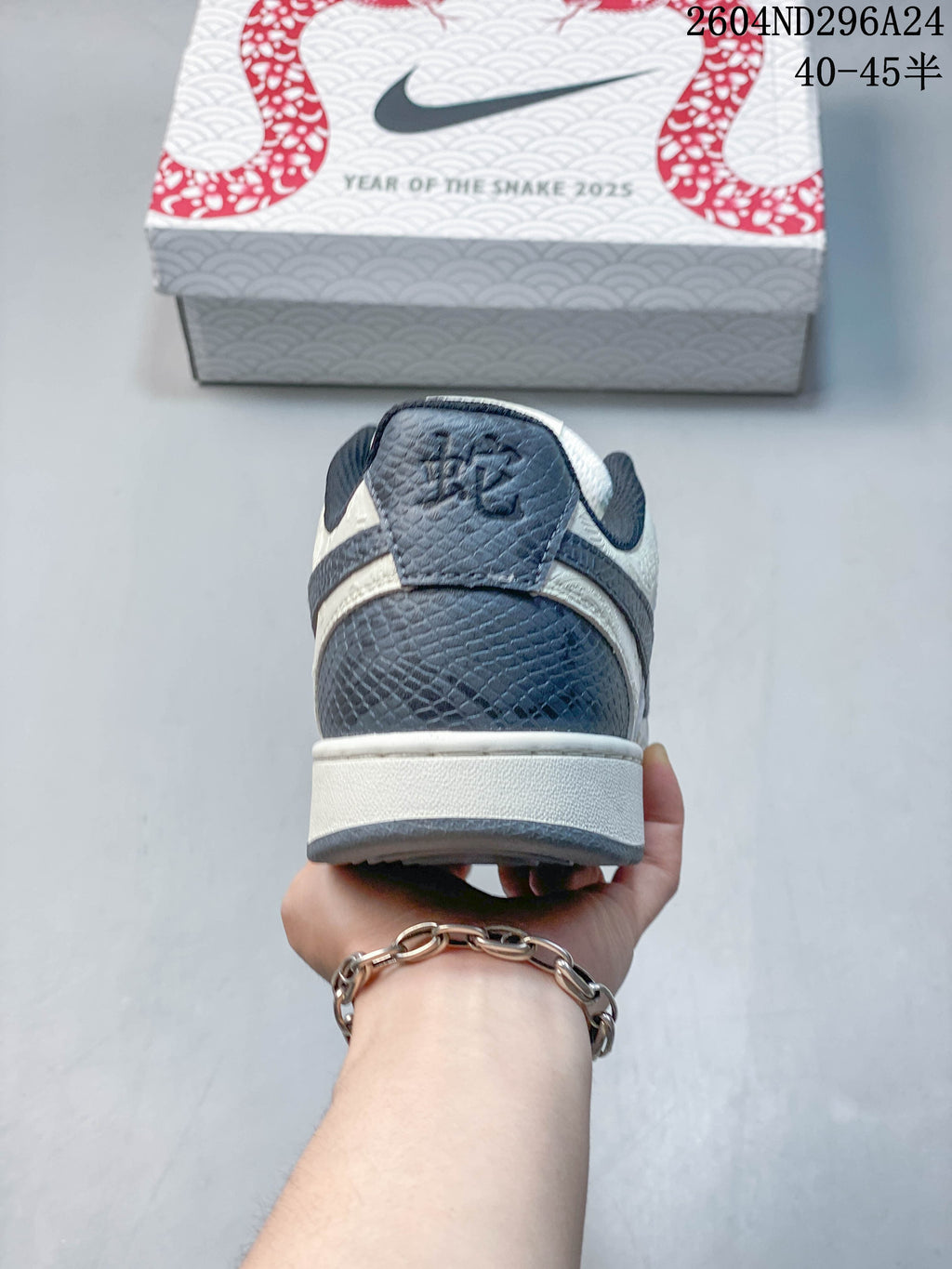 Rear view of the sneaker with a slate-blue textured heel panel and Year of the Snake box