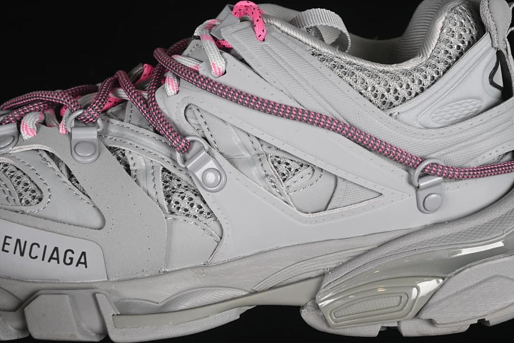 Side close-up showing layered grey panels, mesh sections, and sole details